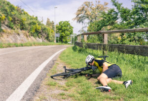A falling bicyclist on road side after crash