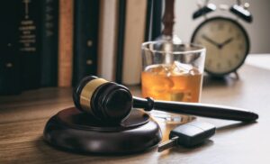 Judge's gavel, a glass of wine and clock in background