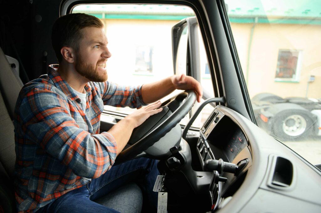 Angry truck driver honking horn and shouting in frustration while sitting in the driver’s seat. Angry truck driver honking horn and shouting in frustration while sitting in the driver’s seat.
