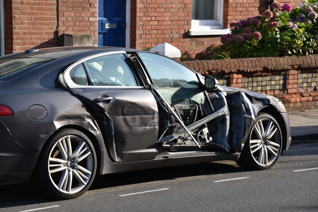 Damaged car with severe side impact and crushed doors after traffic accident.
