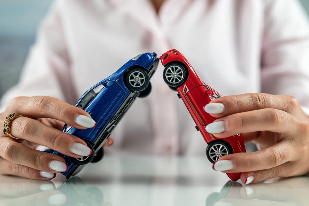 Two toy cars colliding representing driver liability claim