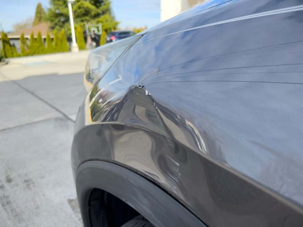 close up of dent and scrape caused by sideswipe accident