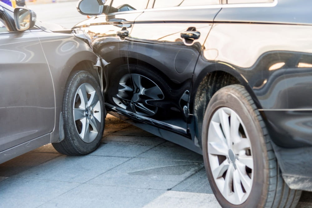 Two vehicles with visible collision damage after a side-impact accident, representing auto insurance claims and accident investigations.