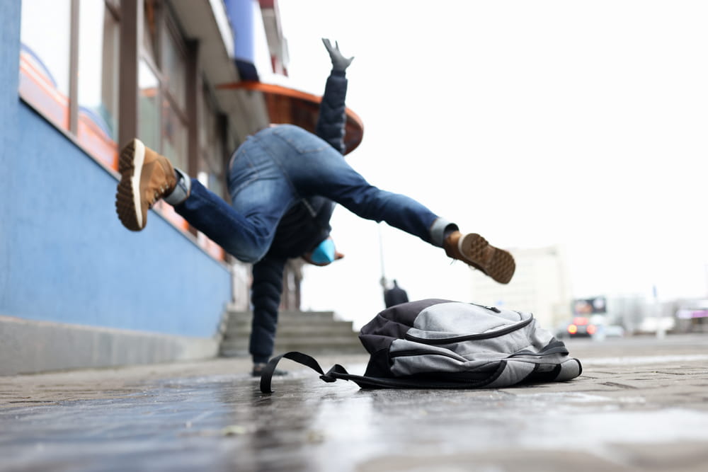 Person slipping on a wet sidewalk outside a business in New Hampshire